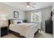 Cozy bedroom with white bedding, a ceiling fan, and natural light from the window at 13822 Worthington Pl, Parker, CO 80134