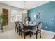 Elegant dining room featuring modern light fixture, blue accent wall, and seating for eight at 13822 Worthington Pl, Parker, CO 80134