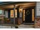 Inviting front porch with brick accents, dark front door, and stylish wreath at 13822 Worthington Pl, Parker, CO 80134