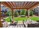 An outdoor covered patio includes chairs, couches, and shade from a pergola with a view of the backyard at 13822 Worthington Pl, Parker, CO 80134