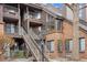 Multi-level condo building with brick and siding exterior, featuring balconies and well-maintained landscaping at 836 S Vance St # E, Lakewood, CO 80226