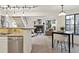 Open living space with fireplace, staircase, and adjacent kitchen, illuminated by modern track lighting and natural light at 836 S Vance St # E, Lakewood, CO 80226