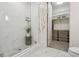 Modern bathroom with a glass-enclosed shower and a view into a walk-in closet at 1735 Central St # 208, Denver, CO 80211