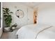 Cozy bedroom with neutral tones, round mirror, and a view to another room at 1735 Central St # 208, Denver, CO 80211
