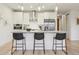 Bright kitchen with white cabinets, stainless steel appliances, and kitchen island with breakfast bar seating at 1735 Central St # 208, Denver, CO 80211