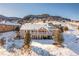 Two-story house exterior with deck and snow-covered yard in mountain setting at 5272 Country Club Dr, Larkspur, CO 80118