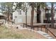 Apartment building exterior with walking path, tidy landscaping, stairs leading to units, and mature trees at 9700 E Iliff Ave # G70, Denver, CO 80231