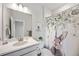 Charming bathroom with white cabinets, a decorative mirror, and a unique shower curtain at 14373 Shasta Daisy Pt, Parker, CO 80134