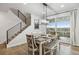 Dining area with modern lighting fixture and backyard views, with a staircase on the side at 14373 Shasta Daisy Pt, Parker, CO 80134