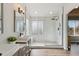 Elegant bathroom with double sinks, stylish lighting, a spacious glass-enclosed shower, and a large window at 1534 Stanley Dr, Erie, CO 80516