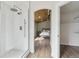 Modern bathroom featuring a glass-enclosed shower and a view into a bedroom with wood-paneled ceiling at 1534 Stanley Dr, Erie, CO 80516