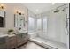 The bathroom showcases a luxurious walk-in shower with a glass enclosure, bench seat, and dual shower heads, along with a double vanity at 1534 Stanley Dr, Erie, CO 80516