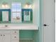 Bathroom features white cabinets, unique mirrors, vanity space and natural light at 1534 Stanley Dr, Erie, CO 80516