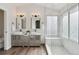 Bright bathroom featuring double vanities, modern fixtures, a window, and a luxurious shower at 1534 Stanley Dr, Erie, CO 80516