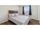 Cozy bedroom with a window, wood-look flooring, and decorative pillows at 1534 Stanley Dr, Erie, CO 80516