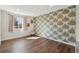 A spacious bedroom with modern wallpaper, laminate floors, and a large window at 1534 Stanley Dr, Erie, CO 80516