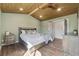 This primary bedroom is spacious with a wood plank ceiling, ceiling fan, and a large bed, creating a luxurious retreat at 1534 Stanley Dr, Erie, CO 80516