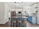 Bright, modern kitchen featuring a large island, stainless steel appliances, and stylish blue and white cabinetry at 1534 Stanley Dr, Erie, CO 80516