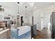 The kitchen island features a large sink and dishwasher with a view into the connected living room with a fireplace at 1534 Stanley Dr, Erie, CO 80516