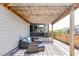 Relaxing backyard patio with a wooden pergola, comfortable seating, and a built-in grill at 6037 N Netherland Ct, Aurora, CO 80019