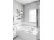 Corner soaking tub with chrome faucet and fixtures, set off by a wall shelf for storage at 6037 N Netherland Ct, Aurora, CO 80019