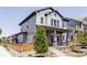 Charming two-story home with a gray exterior, brick accents, and a cozy front porch at 6037 N Netherland Ct, Aurora, CO 80019