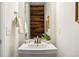 Bathroom featuring a sleek sink, wooden accent wall, and modern fixtures at 18824 Robins Dr, Denver, CO 80249