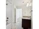 Bright bathroom showcasing white tiled shower, open doorway, granite countertop, and single sink at 18824 Robins Dr, Denver, CO 80249