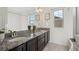 Bright bathroom featuring double vanity, granite countertop, and modern fixtures at 18824 Robins Dr, Denver, CO 80249