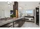 Spacious bathroom featuring double sinks, and a soaking tub with black tile at 18824 Robins Dr, Denver, CO 80249