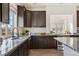 Modern kitchen with dark wood cabinets, granite countertops and stainless steel appliances at 18824 Robins Dr, Denver, CO 80249