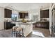 Modern kitchen features a granite island with seating, dark cabinets, and natural light at 18824 Robins Dr, Denver, CO 80249