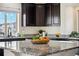 Bright kitchen features granite countertops, stainless steel appliances and ample dark wood cabinetry at 18824 Robins Dr, Denver, CO 80249