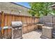 Cozy backyard patio with a grill, wooden fence, and brick pavers for outdoor entertaining at 2564 N Emerson St, Denver, CO 80205