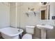 Classic bathroom featuring a clawfoot tub, pedestal sink, and updated fixtures at 2564 N Emerson St, Denver, CO 80205