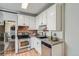 Modern kitchen featuring stainless steel appliances, white cabinets, and exposed brick details adjacent to laundry at 2564 N Emerson St, Denver, CO 80205