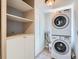Convenient laundry area with stacked washer and dryer, and built-in shelving for storage at 2564 N Emerson St, Denver, CO 80205