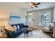 Bright living room featuring a tufted blue sofa, hardwood floors and a ceiling fan at 2564 N Emerson St, Denver, CO 80205