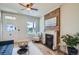 Stylish living room with brick fireplace, hardwood floors, and a cozy armchair and a ceiling fan at 2564 N Emerson St, Denver, CO 80205