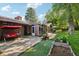 Inviting backyard features a brick patio with swing, garden beds, and mature trees offering a serene outdoor space at 13140 W 15Th Dr, Golden, CO 80401