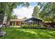 Beautiful backyard with lush lawn, mature trees and a covered patio area at 13140 W 15Th Dr, Golden, CO 80401