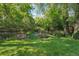 Picturesque backyard featuring a lush lawn, mature trees, and a charming rock pond at 13140 W 15Th Dr, Golden, CO 80401
