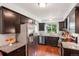 Modern kitchen features stainless steel appliances, granite countertops, dark cabinets, and a window view of the backyard at 13140 W 15Th Dr, Golden, CO 80401