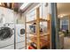 Laundry room with modern washer and dryer and practical wooden storage shelves at 13140 W 15Th Dr, Golden, CO 80401