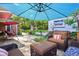 Relaxing outdoor patio area with comfortable seating and a shade umbrella overlooking the beautiful yard at 13140 W 15Th Dr, Golden, CO 80401