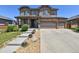 Inviting two-story home featuring a stone facade, three-car garage, and manicured landscaping at 76 N Ider St, Aurora, CO 80018