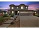 Inviting two-story home featuring a stone facade, three-car garage, and manicured landscaping at 76 N Ider St, Aurora, CO 80018