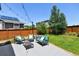 Outdoor patio with lounge furniture, string lights, a wooden fence, and green grass at 76 N Ider St, Aurora, CO 80018