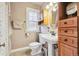 Quaint bathroom featuring a pedestal sink, wooden storage cabinet, and a classic-style toilet at 263 N Logan St, Denver, CO 80203