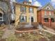 Classic yellow two-story home featuring black shutters and a landscaped front yard with a small porch at 263 N Logan St, Denver, CO 80203
